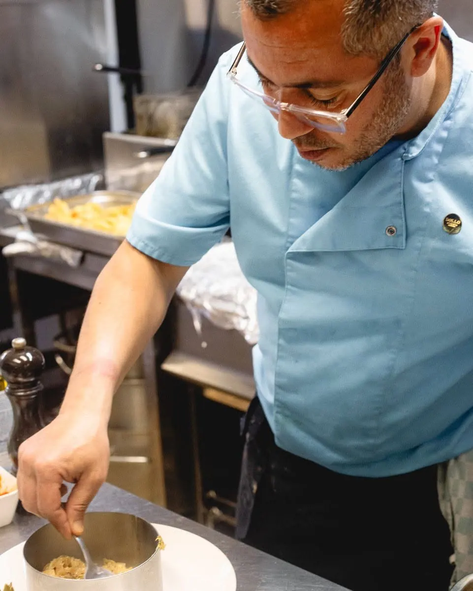 Le chef assaisonne un plat au piano de la cuisine