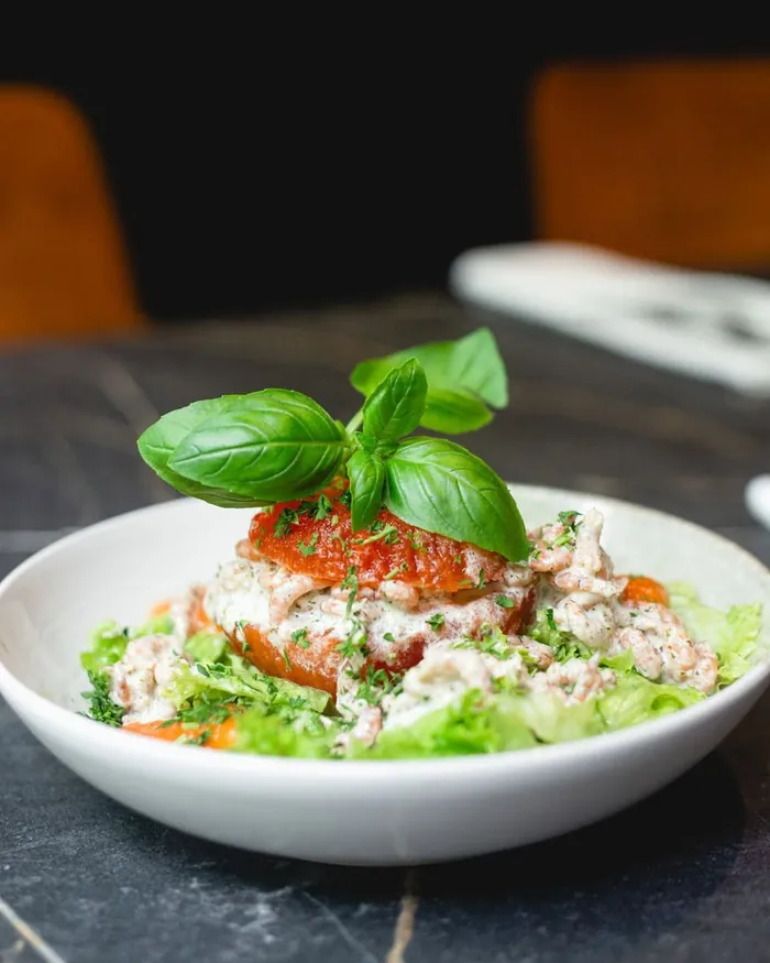 Tomate garnie de crevettes grises, salade et basilic