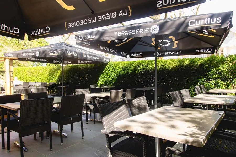 Tables de la terrasse à l’ombre des parasols
