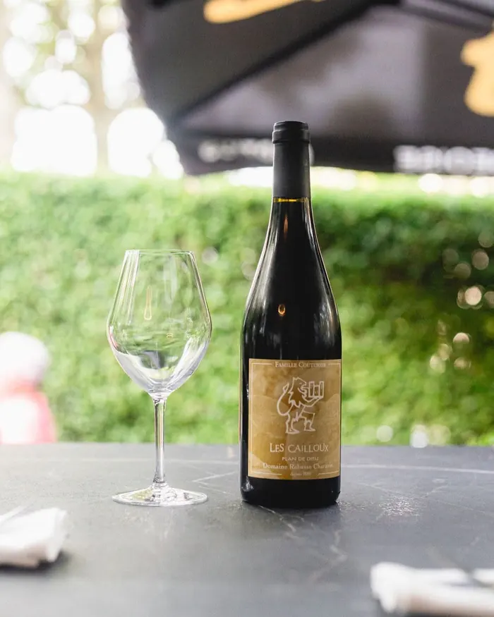 Bouteille de vin rouge et verre sur une table de terrasse